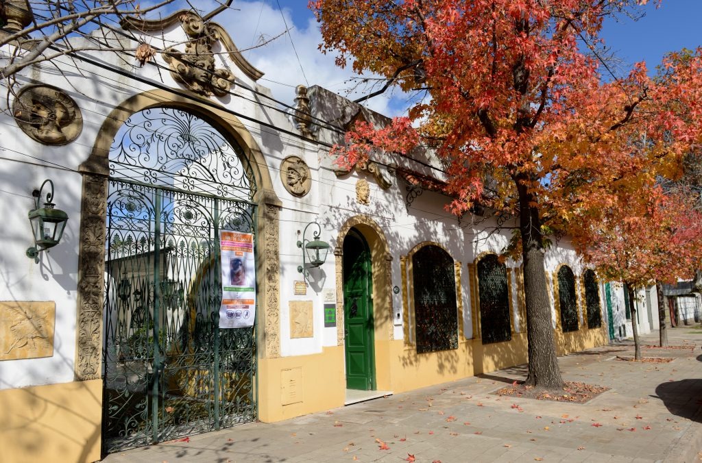 Fachada de la Casa Susana Esther Soba en Saladillo, con árboles de otoño.