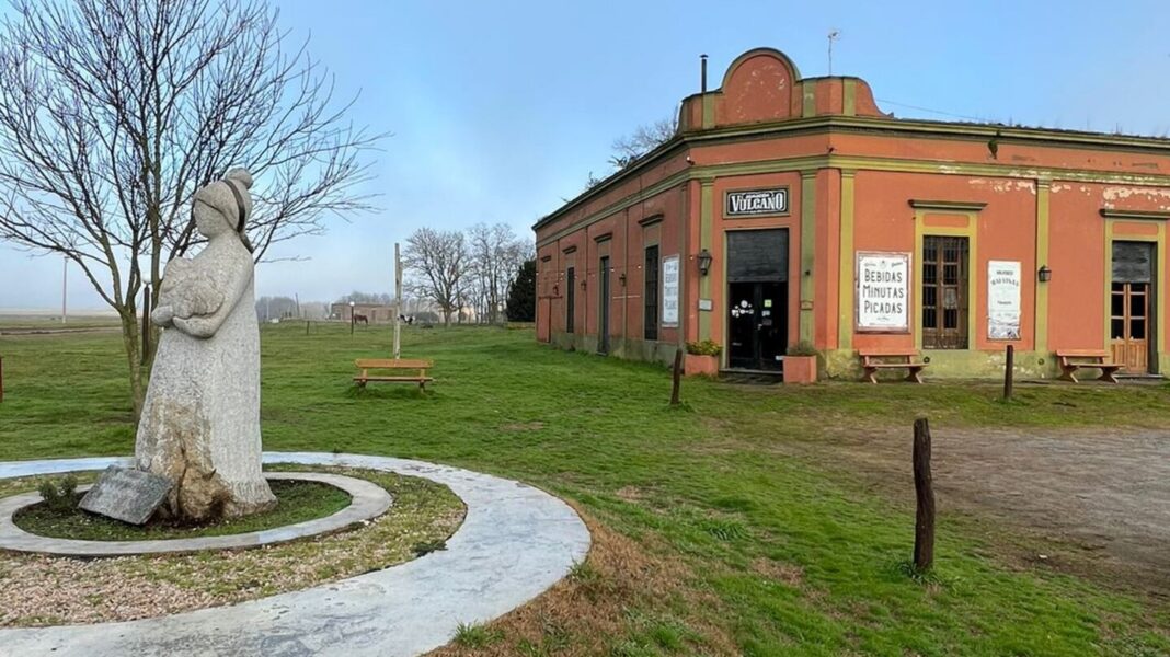 Fachada del Almacén Vulcano en Gardey, Tandil, con escultura y entorno rural.